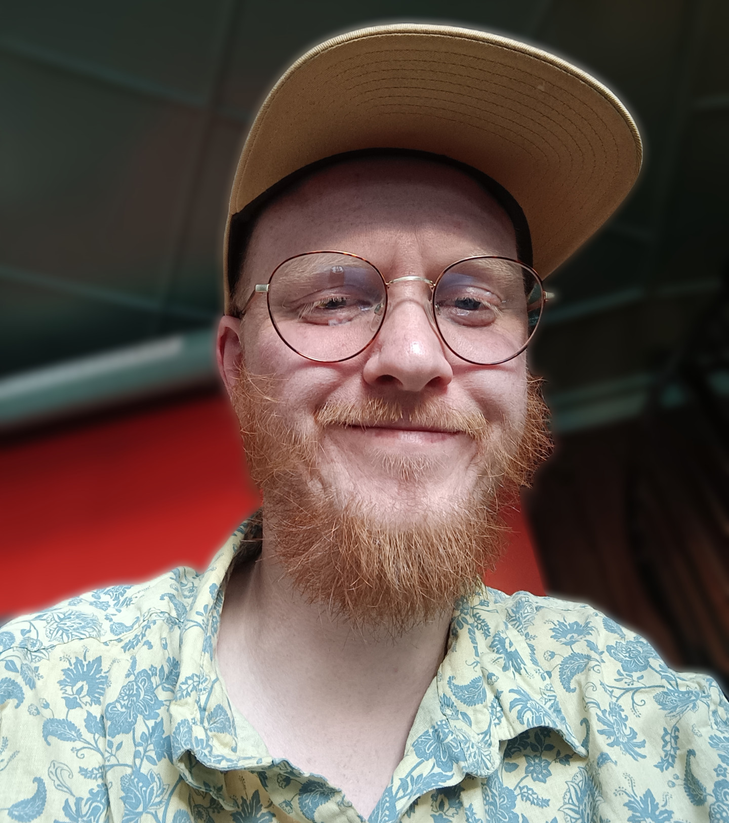 A photo of me. I have glasses, a beard, floral shirt and a hat